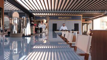 A modern interior with a reflective floor, a bar area with a chef, and a sign reading "BOULANGERIE".