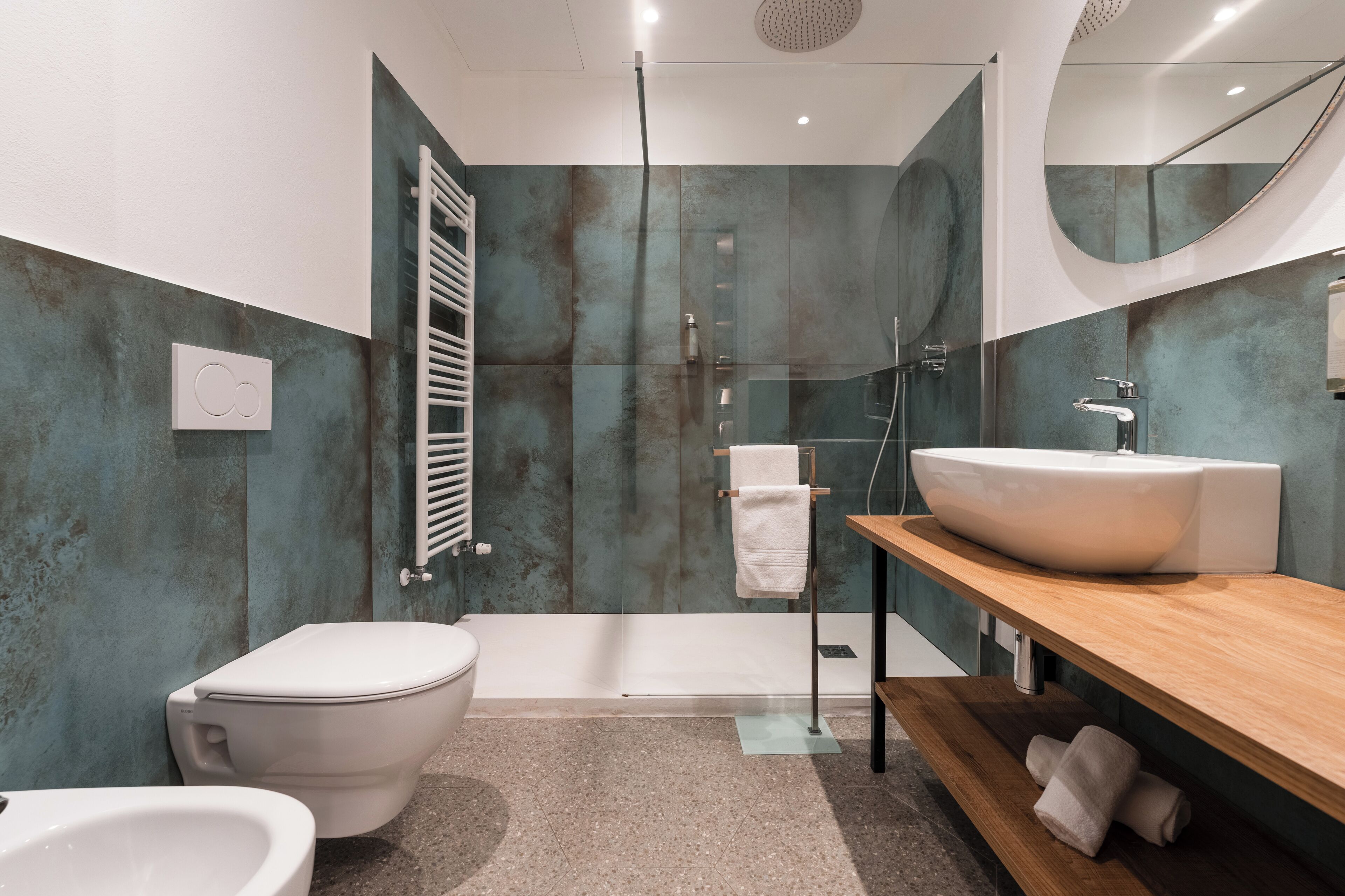Une salle de bain moderne avec un grand lavabo blanc, une douche à parois de verre et des toilettes.