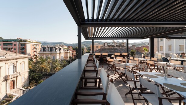 An outdoor terrace with seating and a view of the cityscape. - Albergo Stella Del Mare (Chiavari)