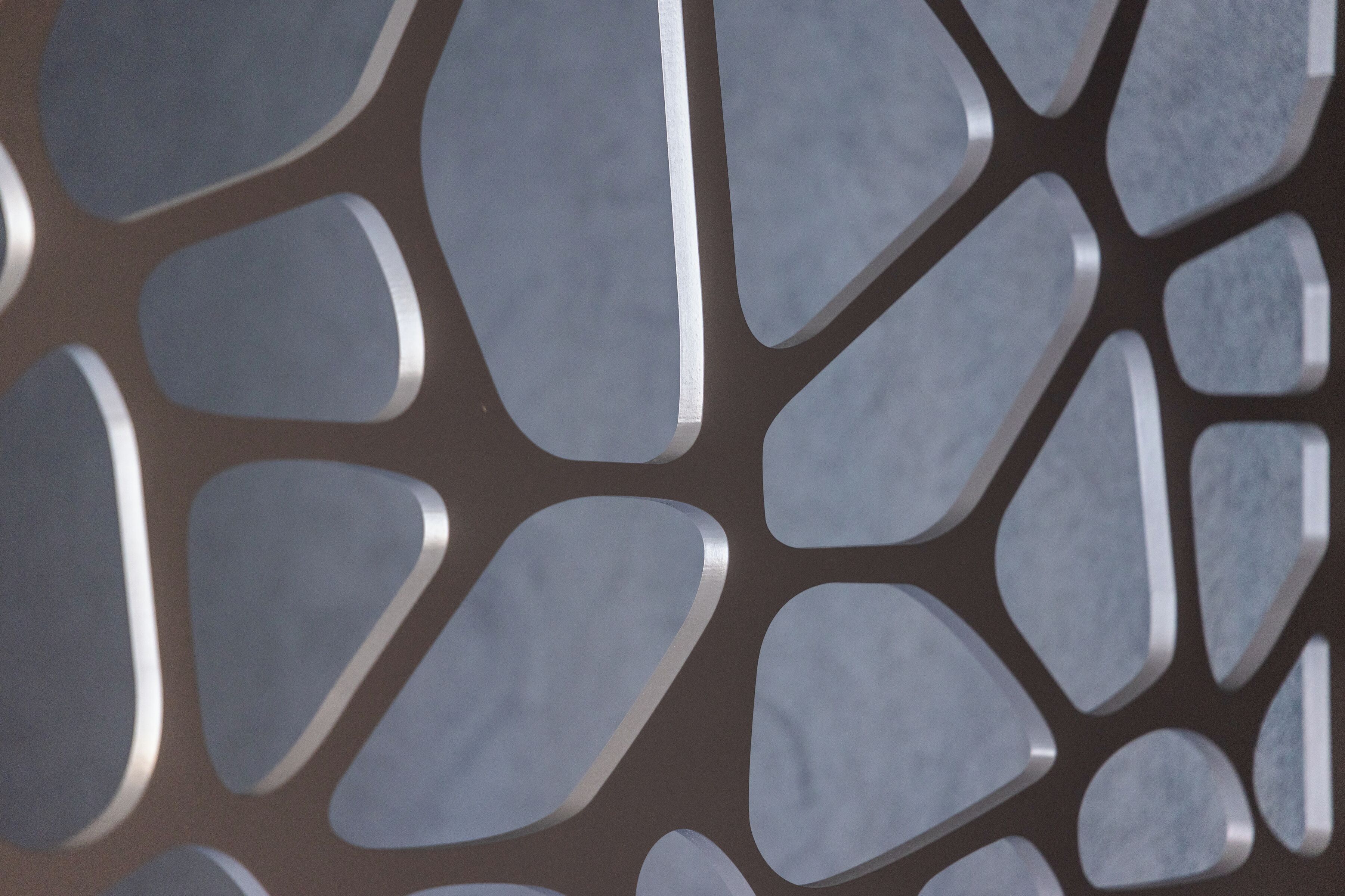 A close-up of a metallic, geometric pattern with interlocking shapes.