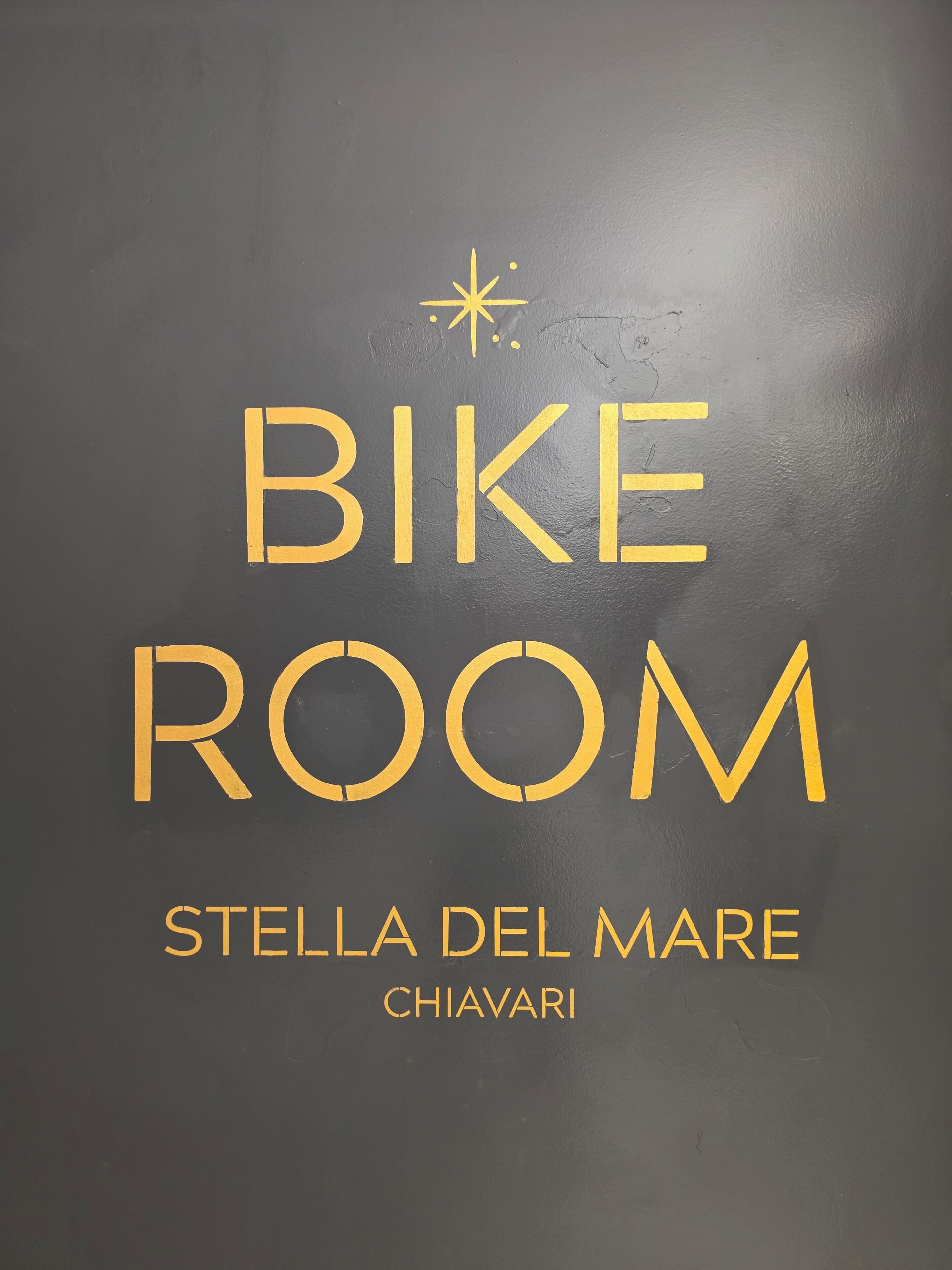 A sign with the text 'BIKE ROOM' and 'STELLA DEL MARE CHIAVARI' indicating a bike storage area at the hotel.
