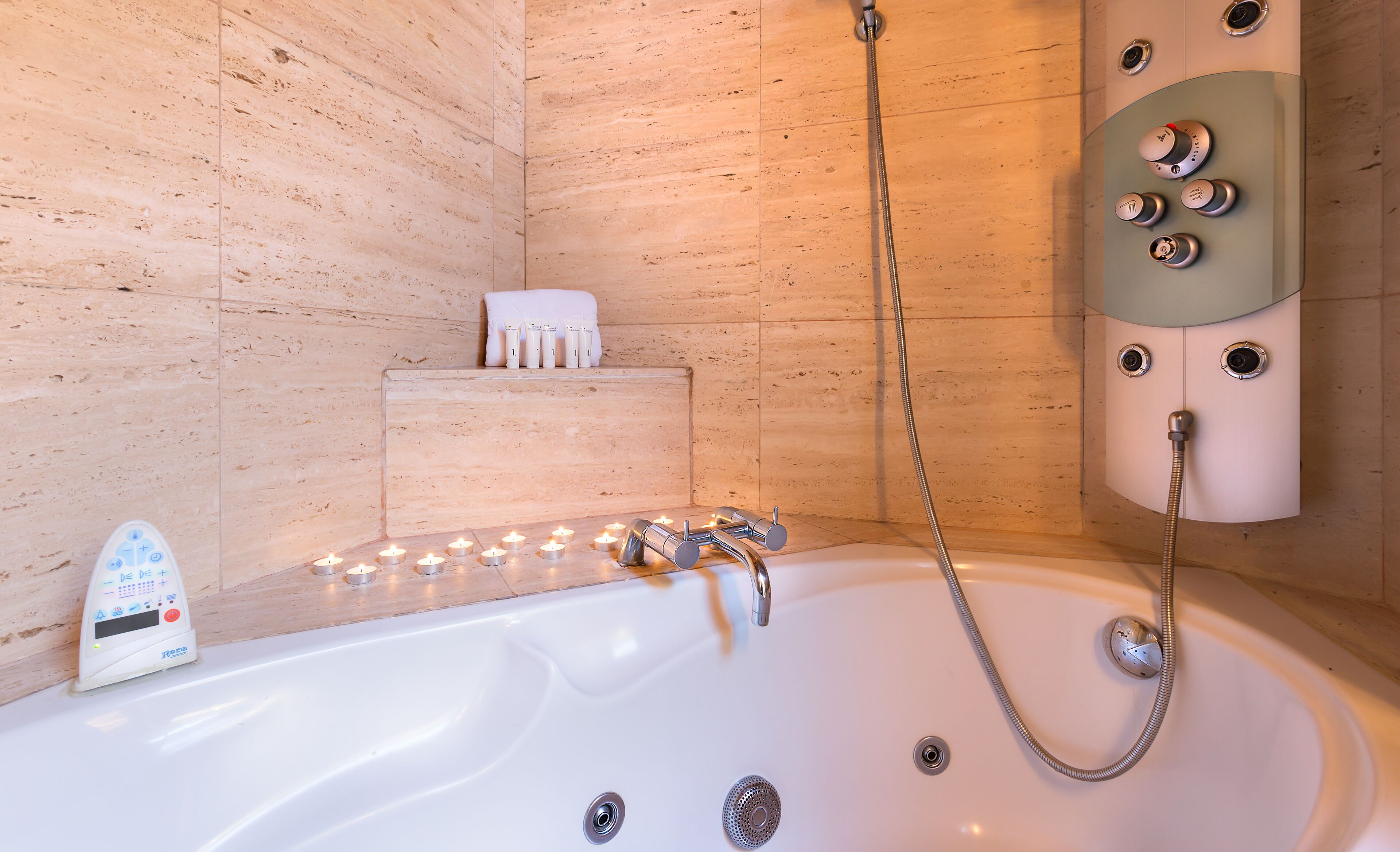 Une salle de bain moderne équipée d’une baignoire, d’un pommeau de douche à main et d’un panneau de commande doté de plusieurs boutons.