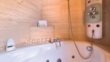 Une salle de bain moderne équipée d’une baignoire, d’un pommeau de douche à main et d’un panneau de commande doté de plusieurs boutons.