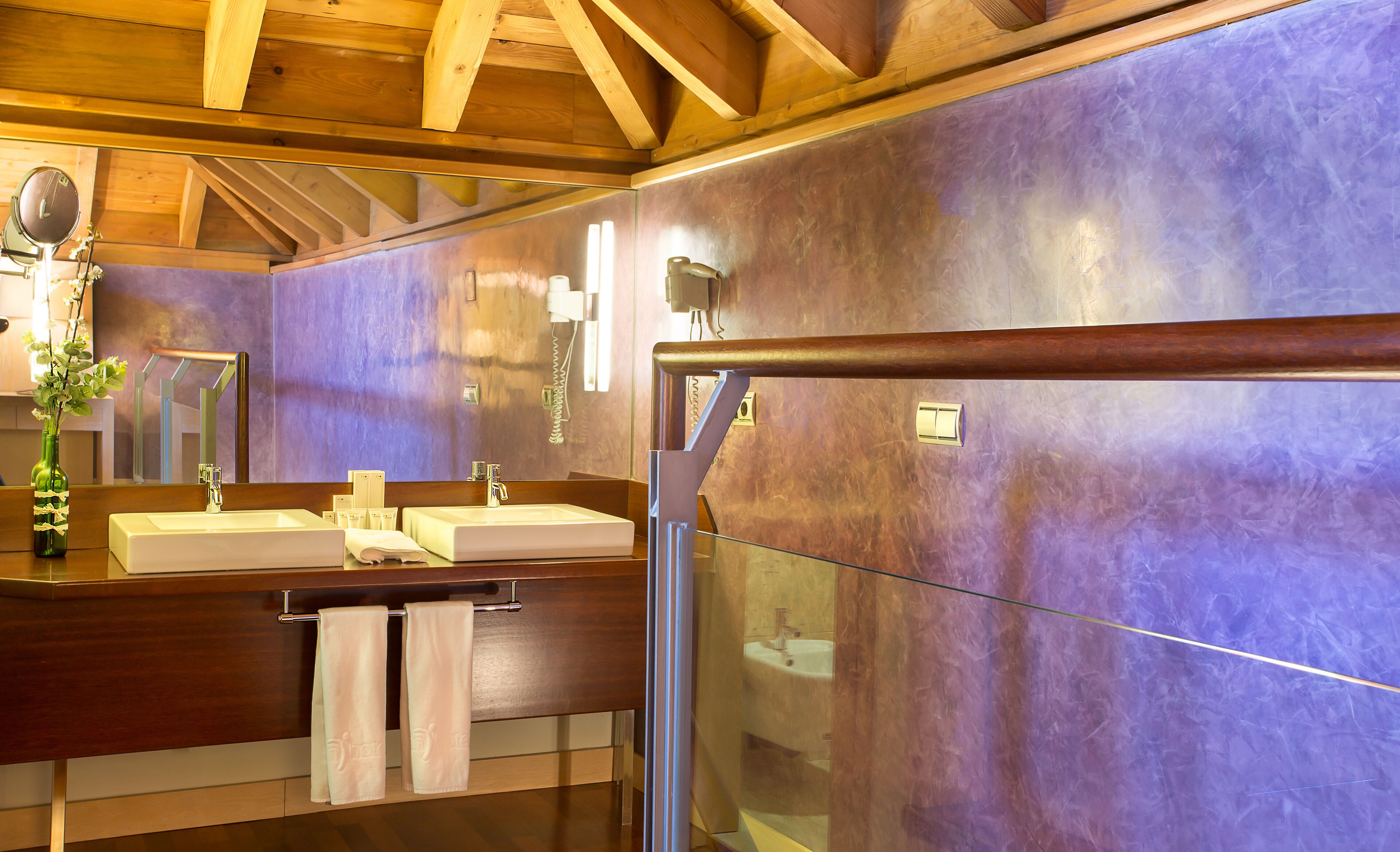 Un bagno con due lavandini, uno specchio e un box doccia in vetro.