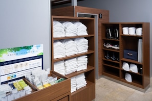 A hotel room with neatly stacked white towels, a wooden shelf with toiletries, and a signboard with amenities information. - Sotetsu Fresa Inn Tokyo-Akasaka (Tokyo)
