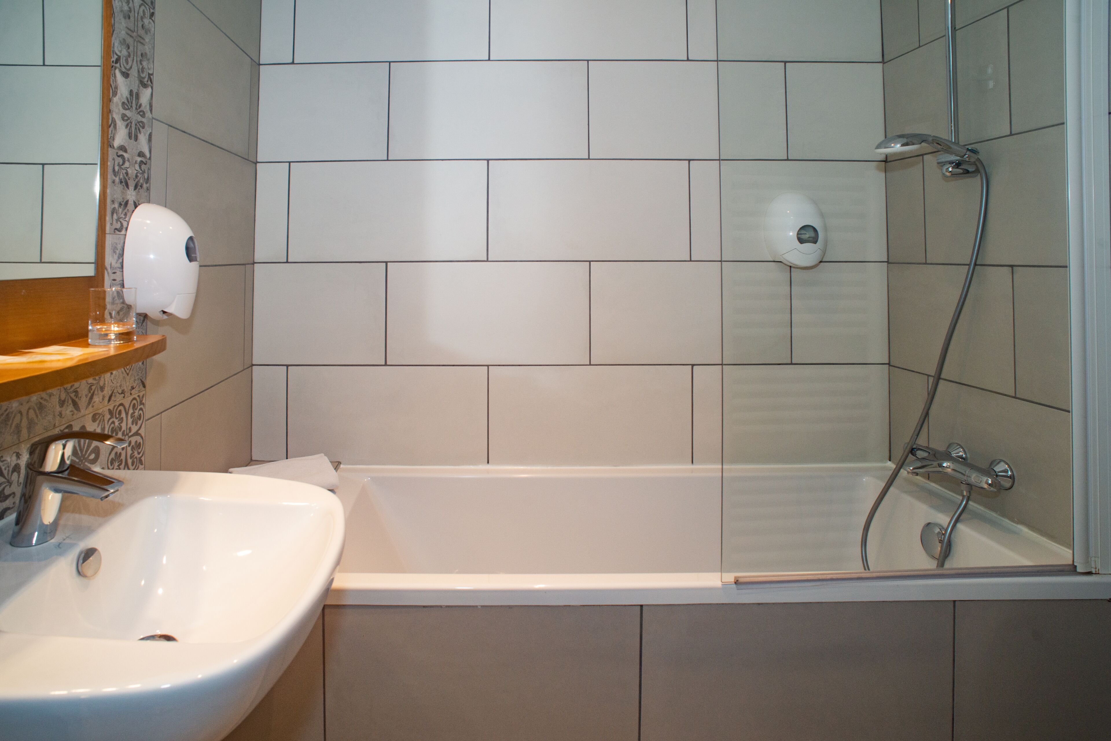 Un baño con lavamanos, espejo y ducha.