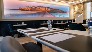 A conference room with a large cityscape painting on the wall, tables with nameplates, and water bottles on the tables.