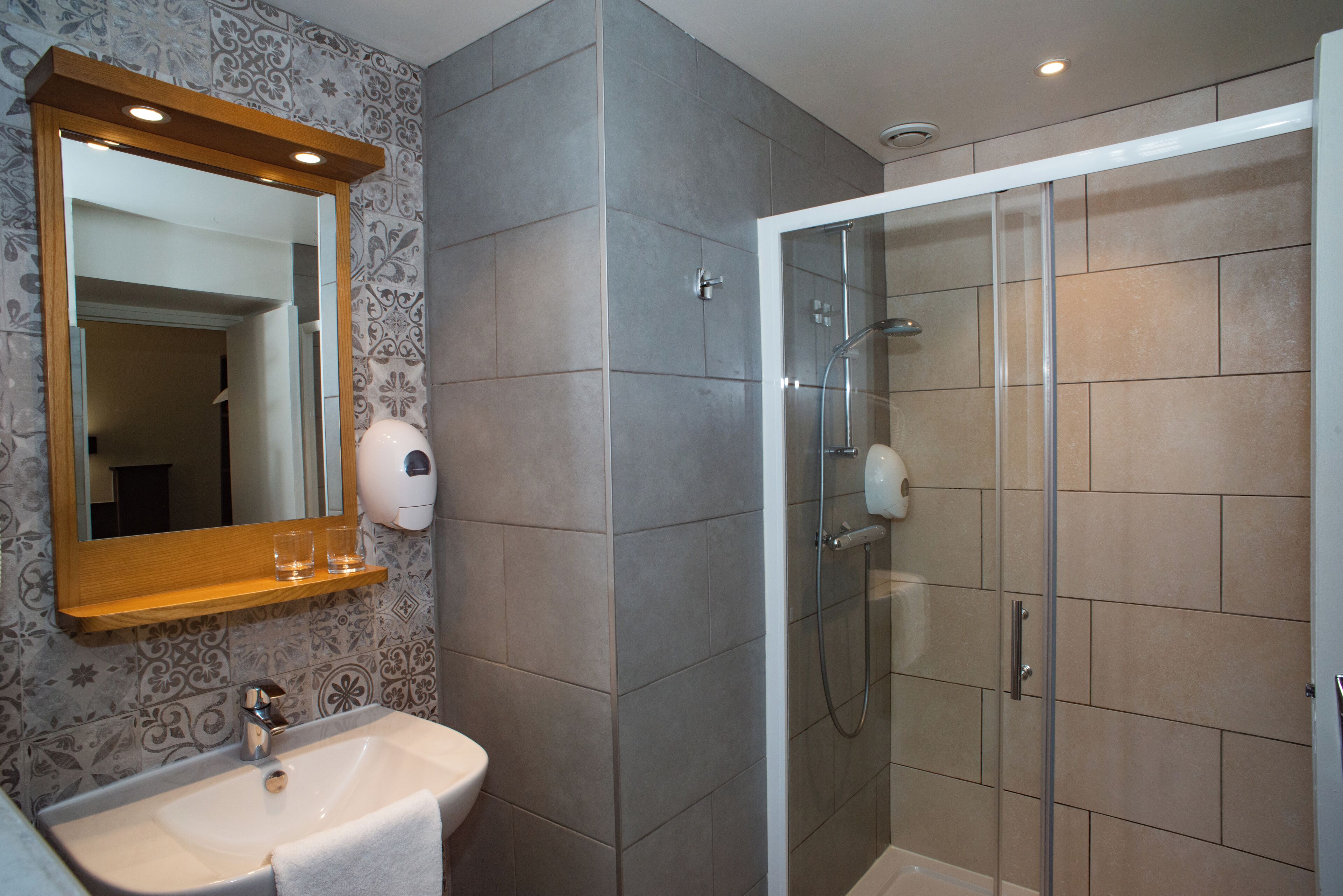 Ein Badezimmer mit Waschbecken, Spiegel und Dusche.