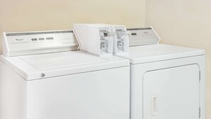Twee witte Whirlpool wasmachines met voorlader en bedieningspanelen.
