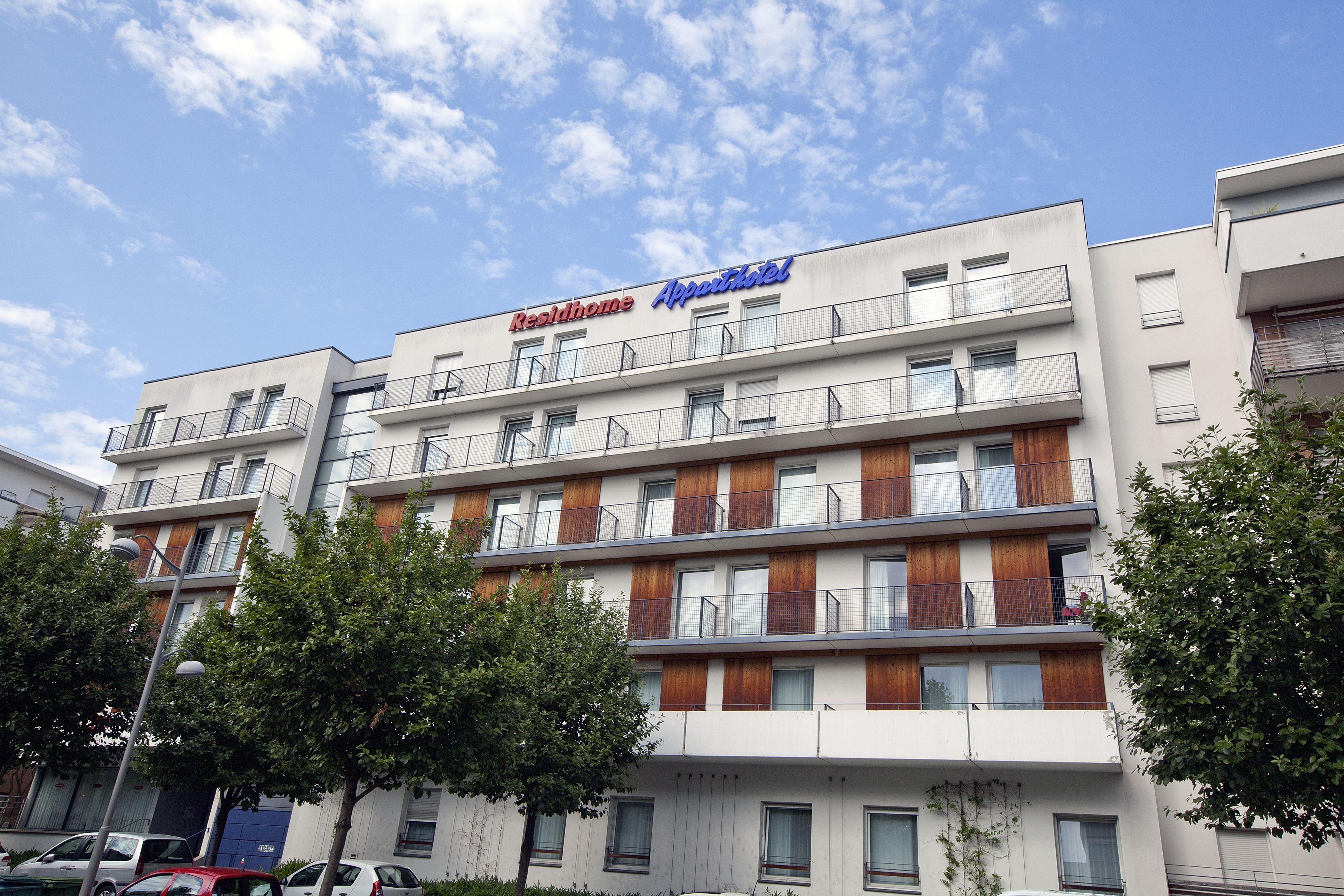 A multi-story hotel with balconies and a sign reading "RestHome AppartmentHotel".