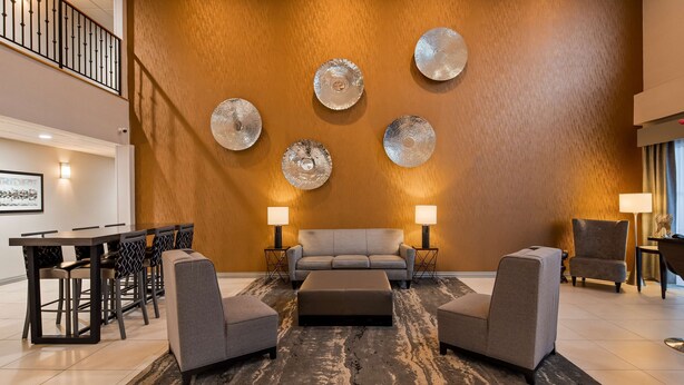 Una sala de estar moderna con un sofá, dos sillones, una mesa de centro y un comedor con una mesa y sillas.