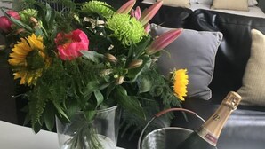 A room with a bed, a nightstand, a lamp, a vase with flowers, and a champagne bottle in a bucket. - Walworth Castle Hotel, BW Signature Collection (Darlington)