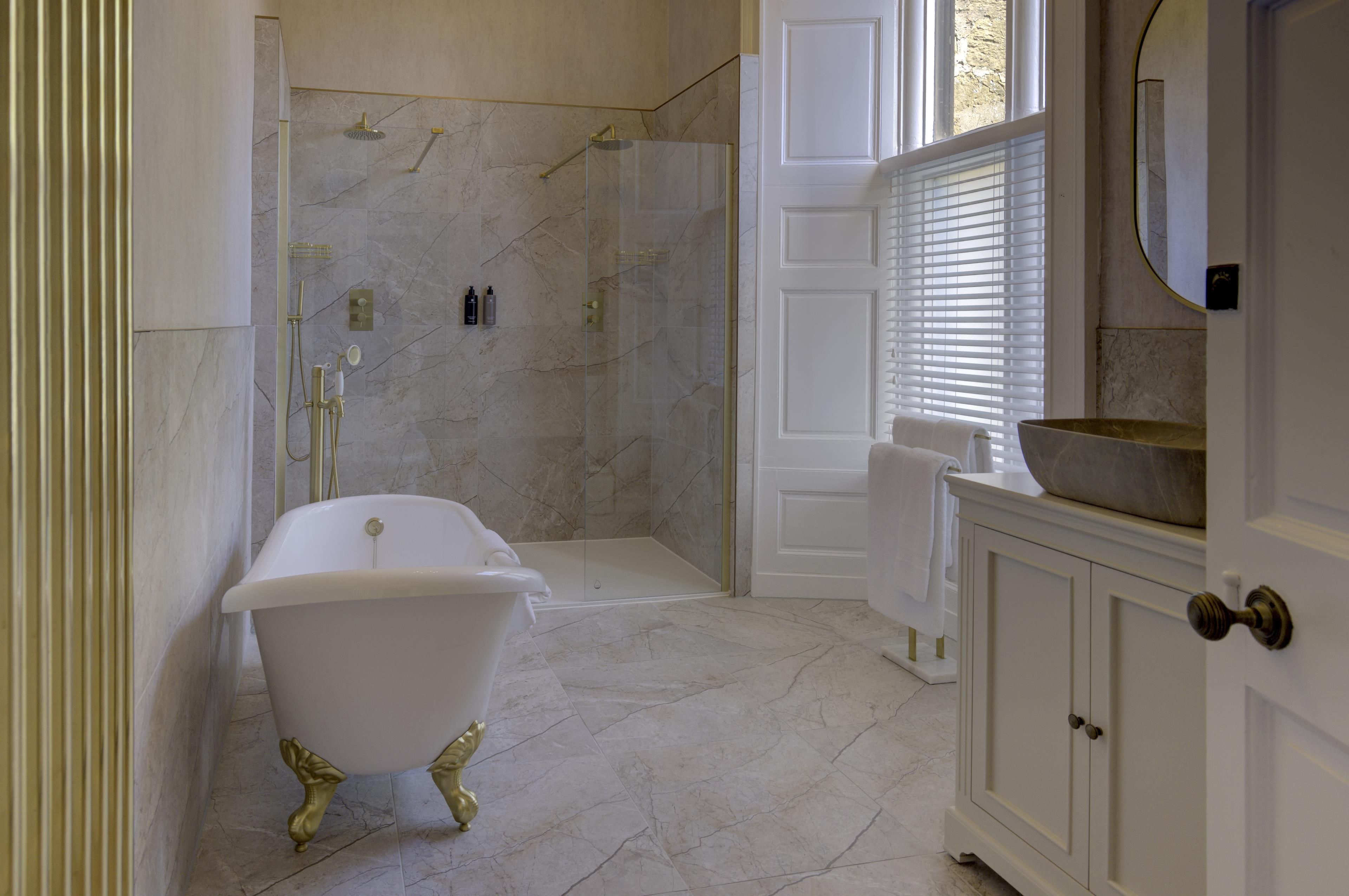Un bagno con una vasca freestanding, uno spazio doccia e un mobile lavabo.