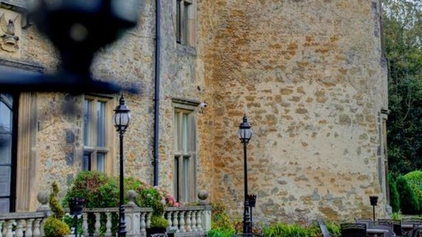 A stone tower with a balcony, outdoor seating area with tables and chairs, and a lamp post. - Walworth Castle Hotel, BW Signature Collection (Darlington)