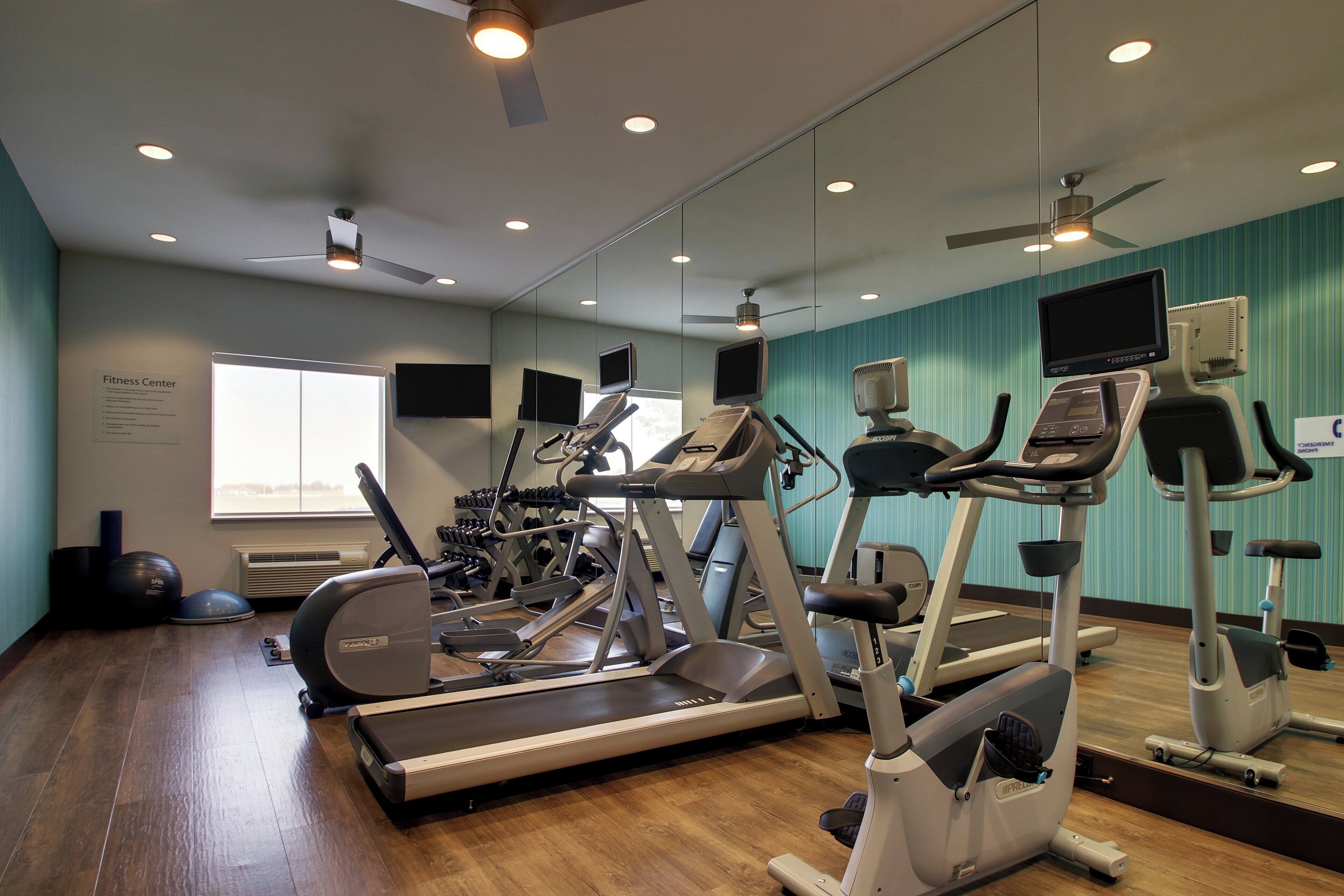 A fitness center with treadmills, elliptical machines, and exercise bikes.