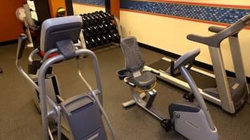 Ett gym med motionscyklar, ett löpband och en stol.