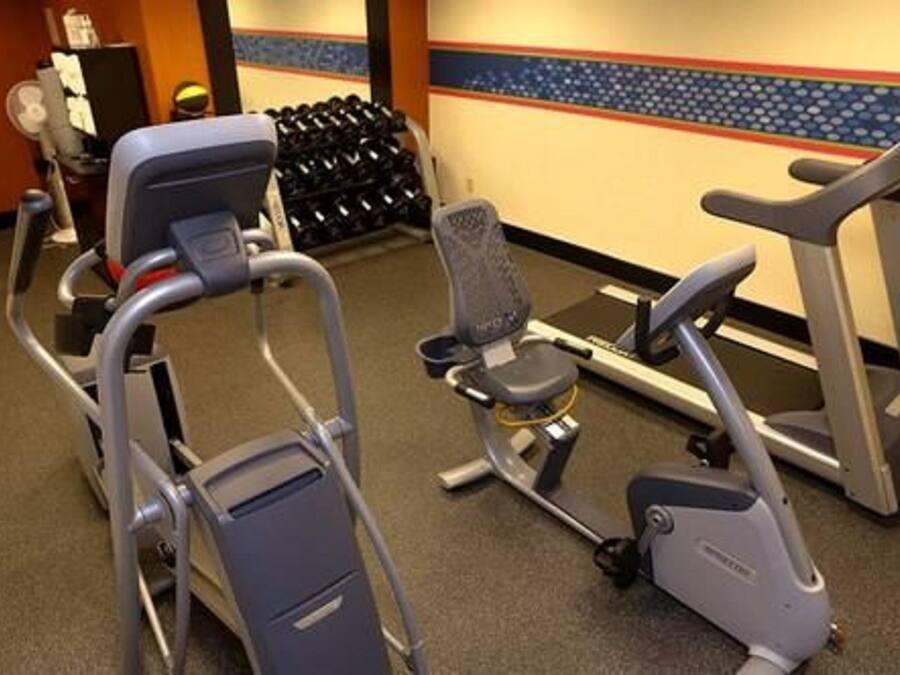 Ett gym med motionscyklar, ett löpband och en stol.