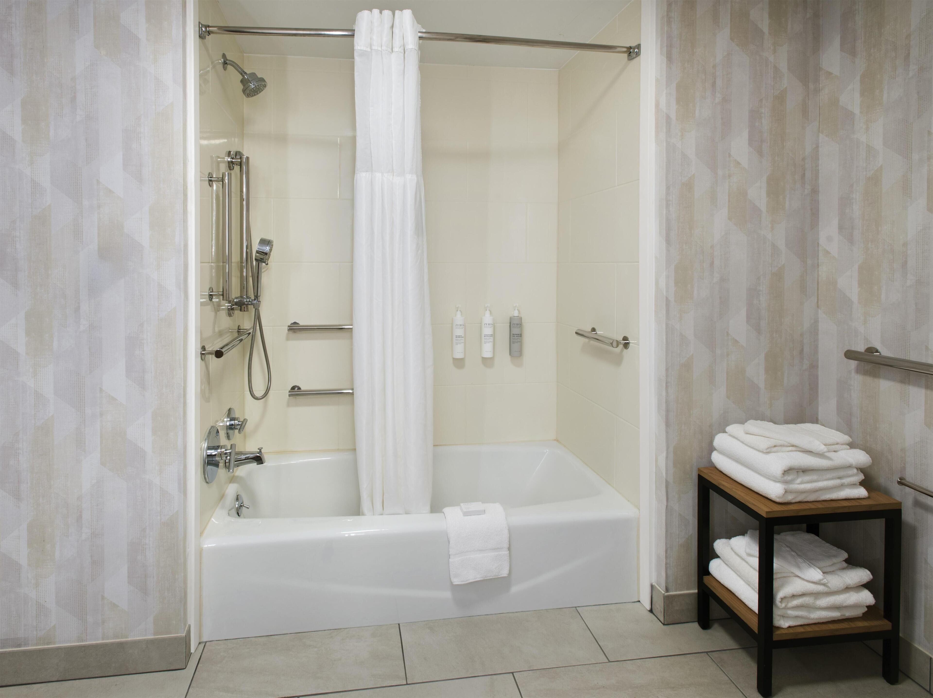 Un baño moderno con bañera, ducha y toallero.