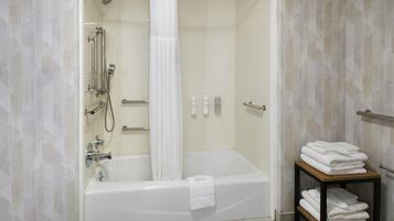 Un baño moderno con bañera, ducha y toallero.