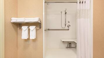 A shower with a handheld showerhead, a handheld showerhead, and a handheld showerhead.