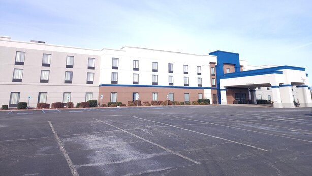 A large, multi-story hotel with a parking lot in front.