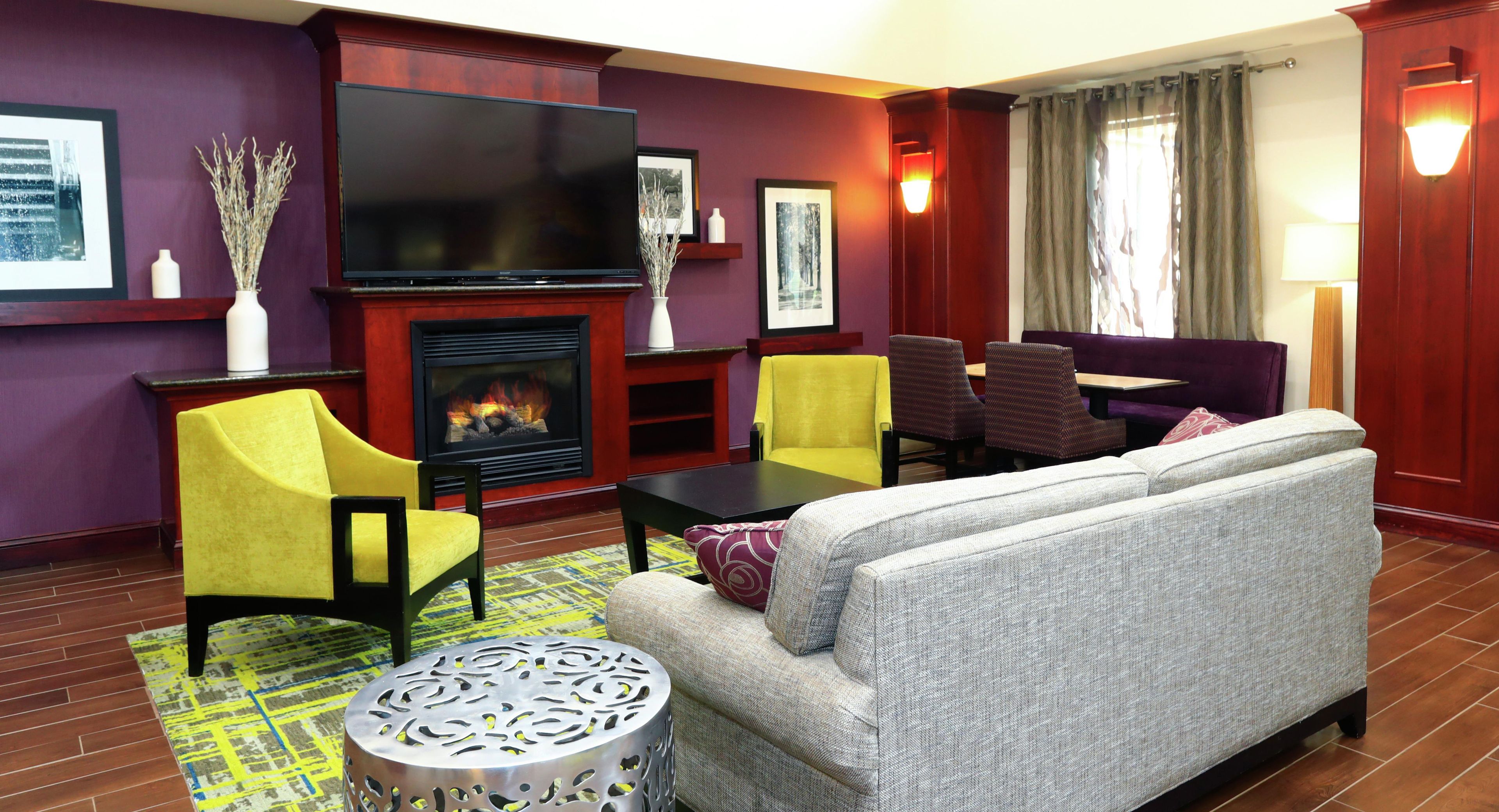 A living room with a fireplace, a television, and seating arrangements.