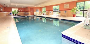 An indoor swimming pool with clear water, lounge chairs, and potted plants. - Hampton Inn & Suites Lamar (Mill Hall)