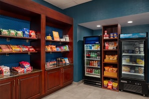 Un área de venta automática con aperitivos y bebidas de diversas marcas, incluyendo papas fritas, snacks y refrescos.