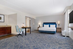 A hotel room with a bed, a desk, a chair, a nightstand, a lamp, a wardrobe, and a bathroom. - Hampton Inn & Suites Lamar (Mill Hall)