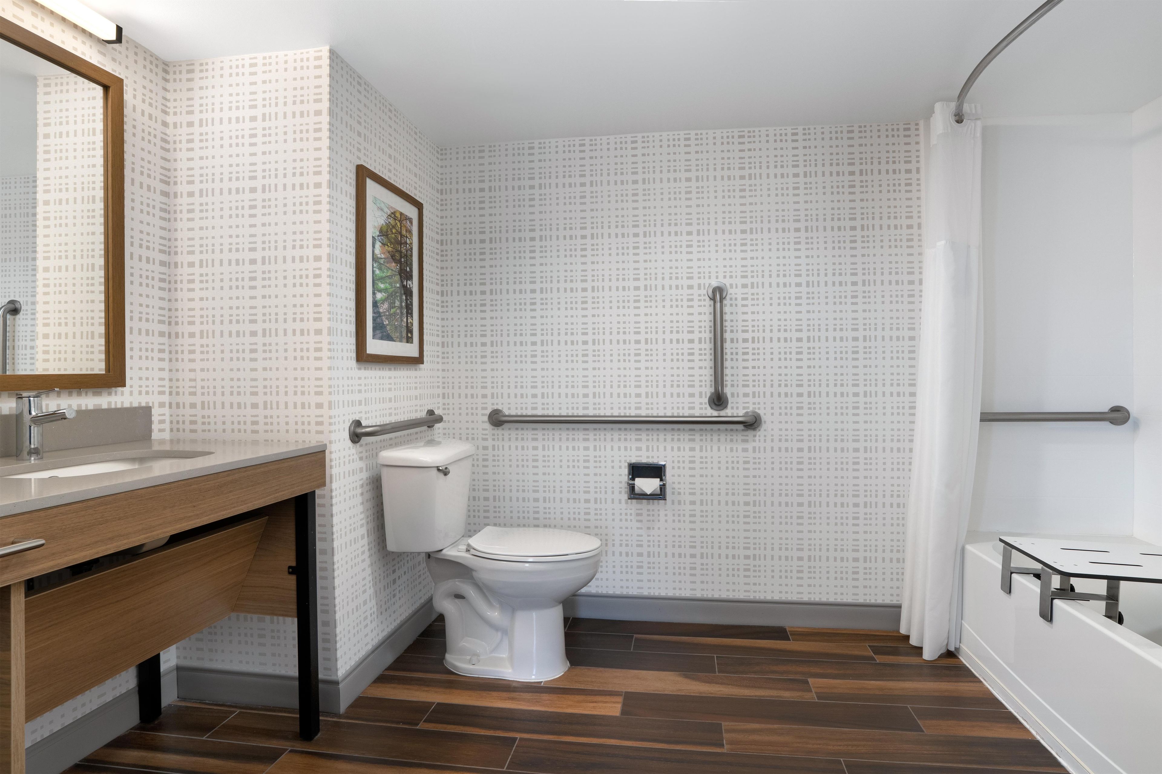 A bathroom with a toilet, sink, and shower.