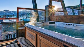 A hot tub with a view of mountains and a cityscape. - Newpark Resort (Park City)