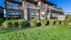 A modern two-story house with large windows, a balcony, and a well-maintained lawn. - Newpark Resort (Park City)