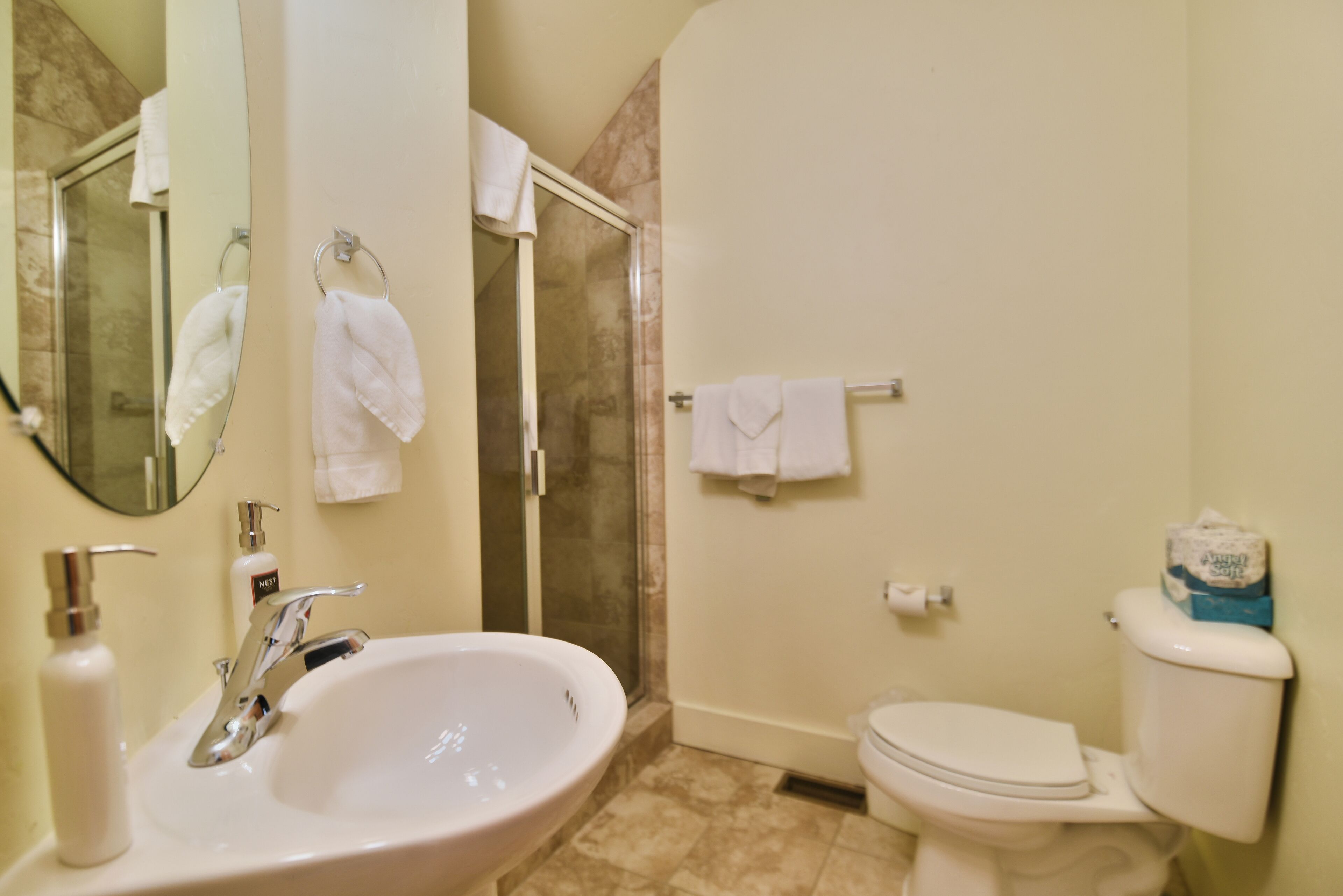 Un baño con lavabo, espejo, ducha e inodoro.