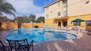 A swimming pool with lounge chairs and a building in the background. - La Quinta Inn & Suites by Wyndham Pasadena (Pasadena)
