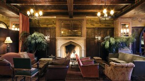 A traditional interior with a fireplace, wooden ceiling, and classic furniture. - The Bowery Hotel (New York)