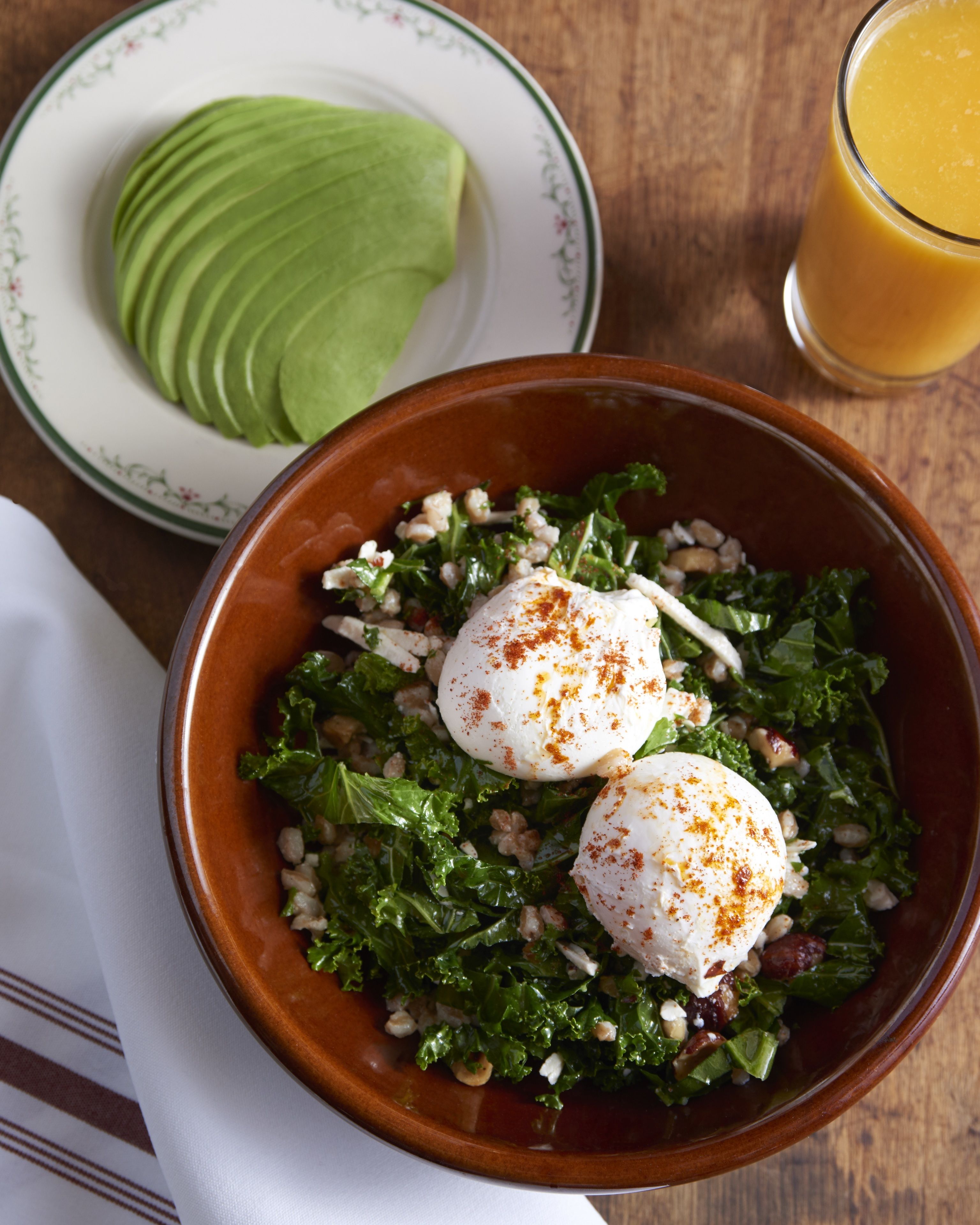 Ensalada con huevos escalfados y una rebanada de aguacate en un plato.