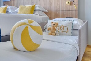 Et hotelværelse med to senge, en natlampe og en strandbold.