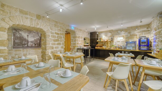 Un restaurante con paredes de piedra, mesas y sillas de madera.