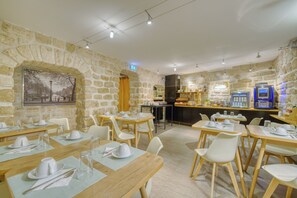 Un restaurante con paredes de piedra, mesas y sillas de madera.