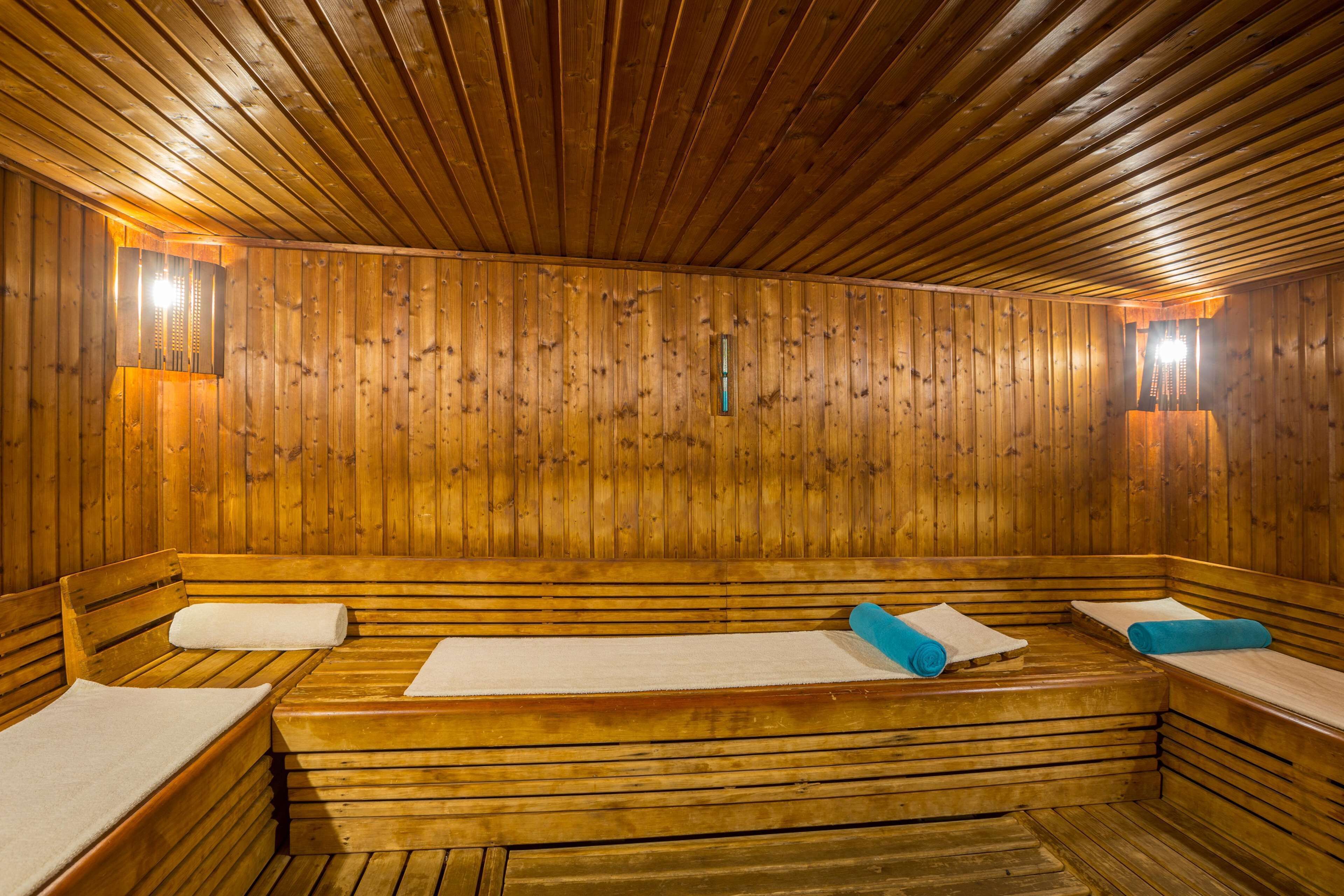 A wooden sauna with benches and benches with towels.