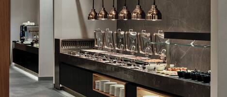 A buffet setup with multiple serving stations, including glass containers and plates.