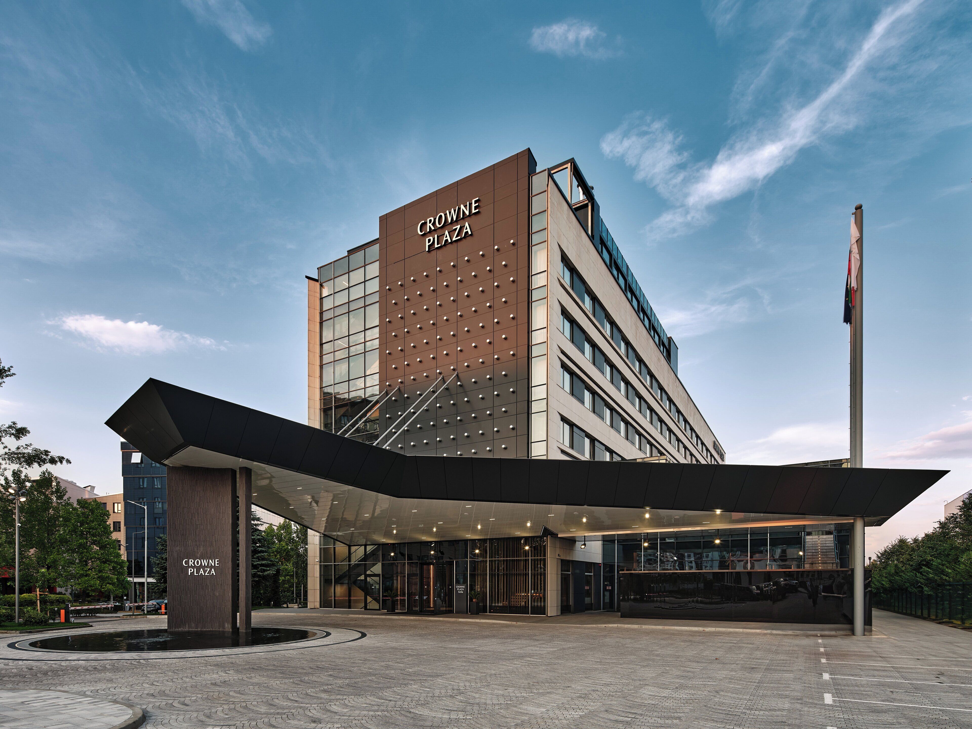 Edifici modern amb el rètol "CROWNE PLAZA", que indica un hotel o un edifici comercial.