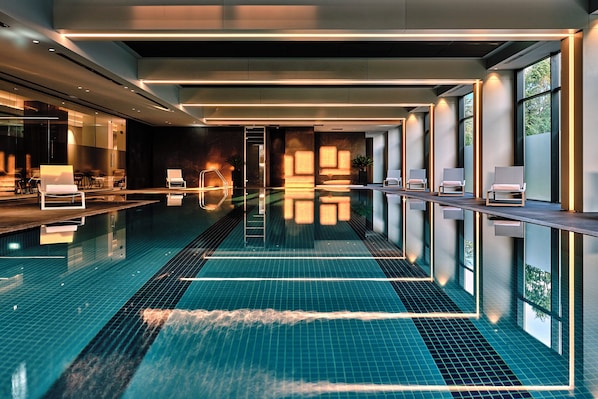 Una piscina techada, sillones reclinables de piscina