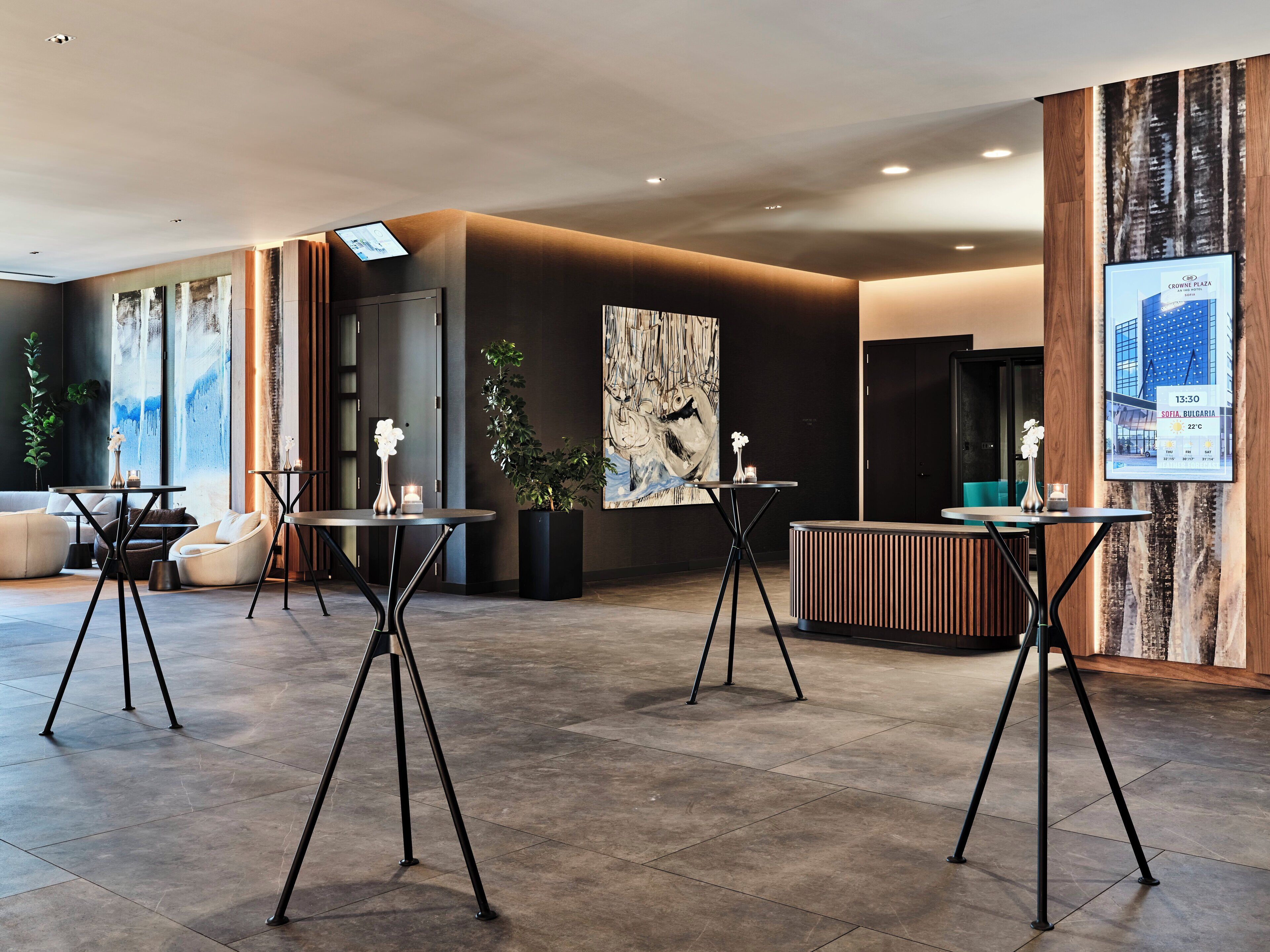 A modern lobby with a reception desk, seating area, and artwork.