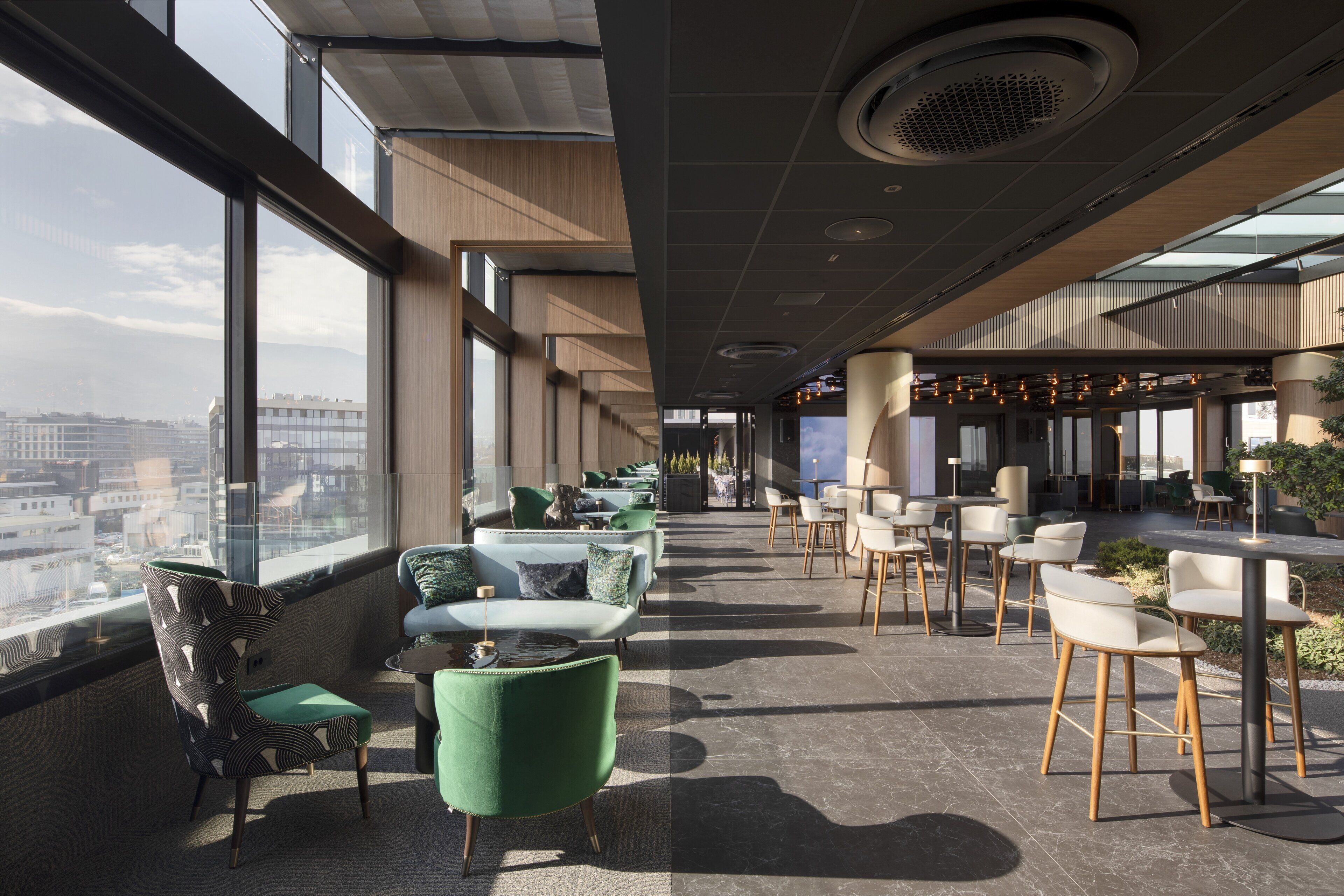 A modern lounge area with seating arrangements and a view of the cityscape.