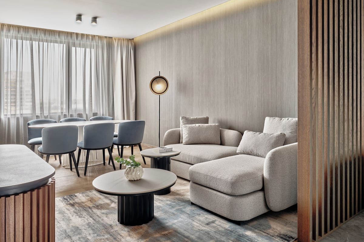 A modern living room with a sofa, chairs, a coffee table, and a floor lamp.