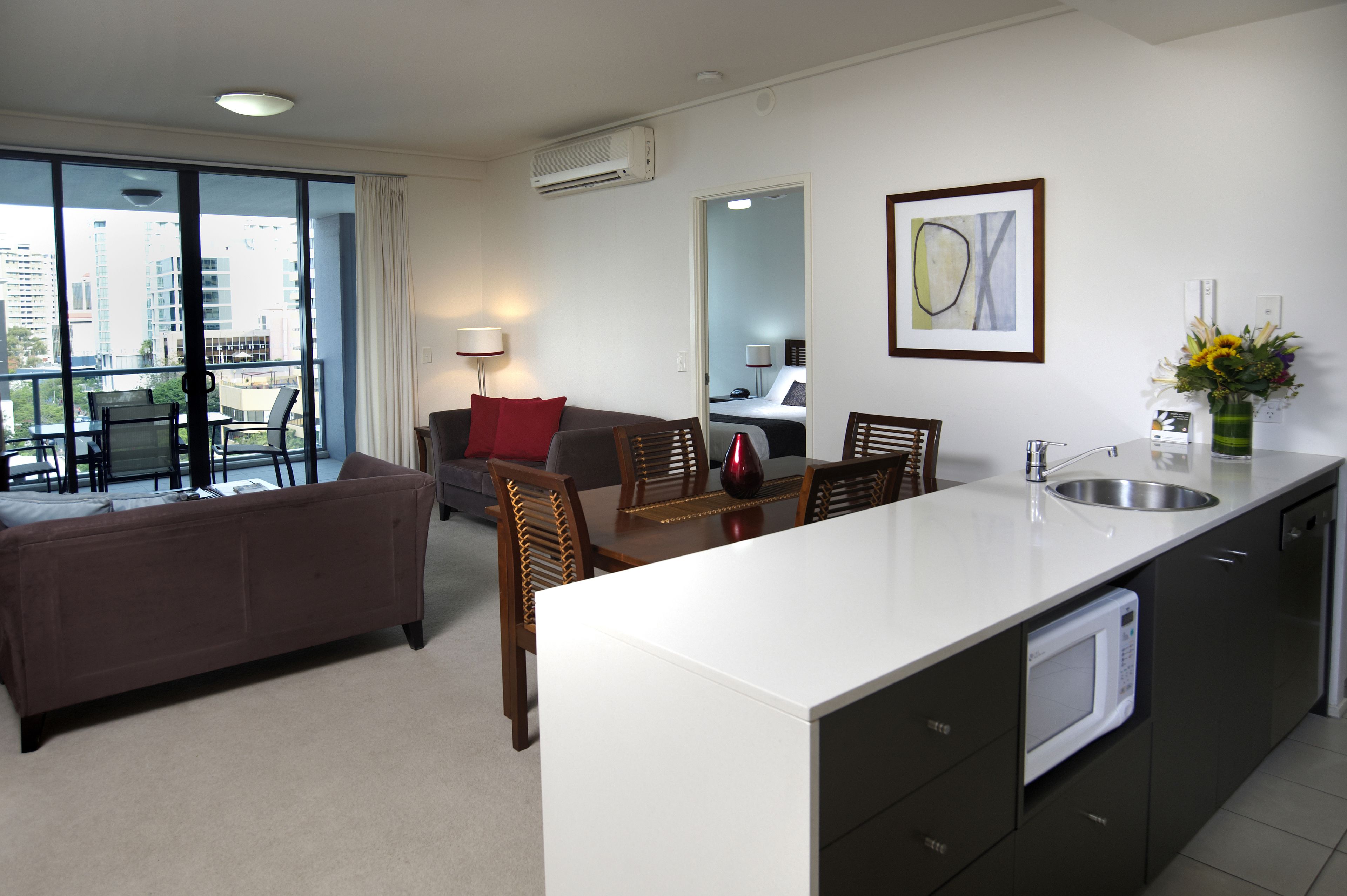 A modern apartment with a living area, dining space, and kitchenette.