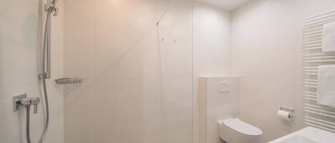 A modern bathroom with a glass-enclosed shower, a toilet, and a bathtub.