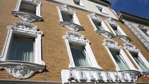 Un bâtiment doté de nombreuses fenêtres et d’une enseigne sur laquelle on peut lire « ADLER ».