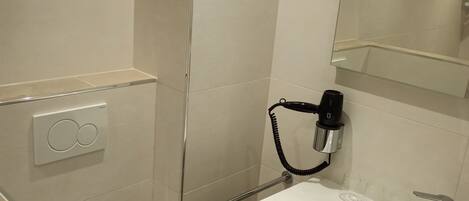 Un bagno piccolo e moderno con servizi igienici, lavandino e doccia.